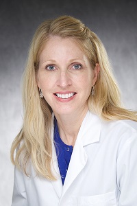 Dr. Messingham is a woman with long blonde hair wearing a white lab coat.