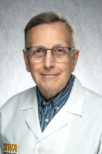 Dr. Cleveland, a man in a white coat and glasses.