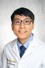 Dr. Cheung, a smiling man wearing glasses and a white coat