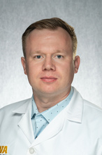Dr. Kidacki, a man wearing a blue shirt and white coat