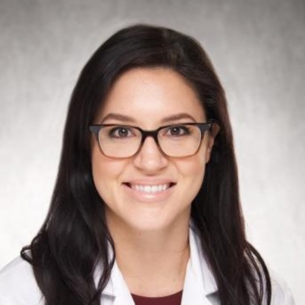 Gretchen Parris, a dark-haired woman wearing glasses and a white coat.