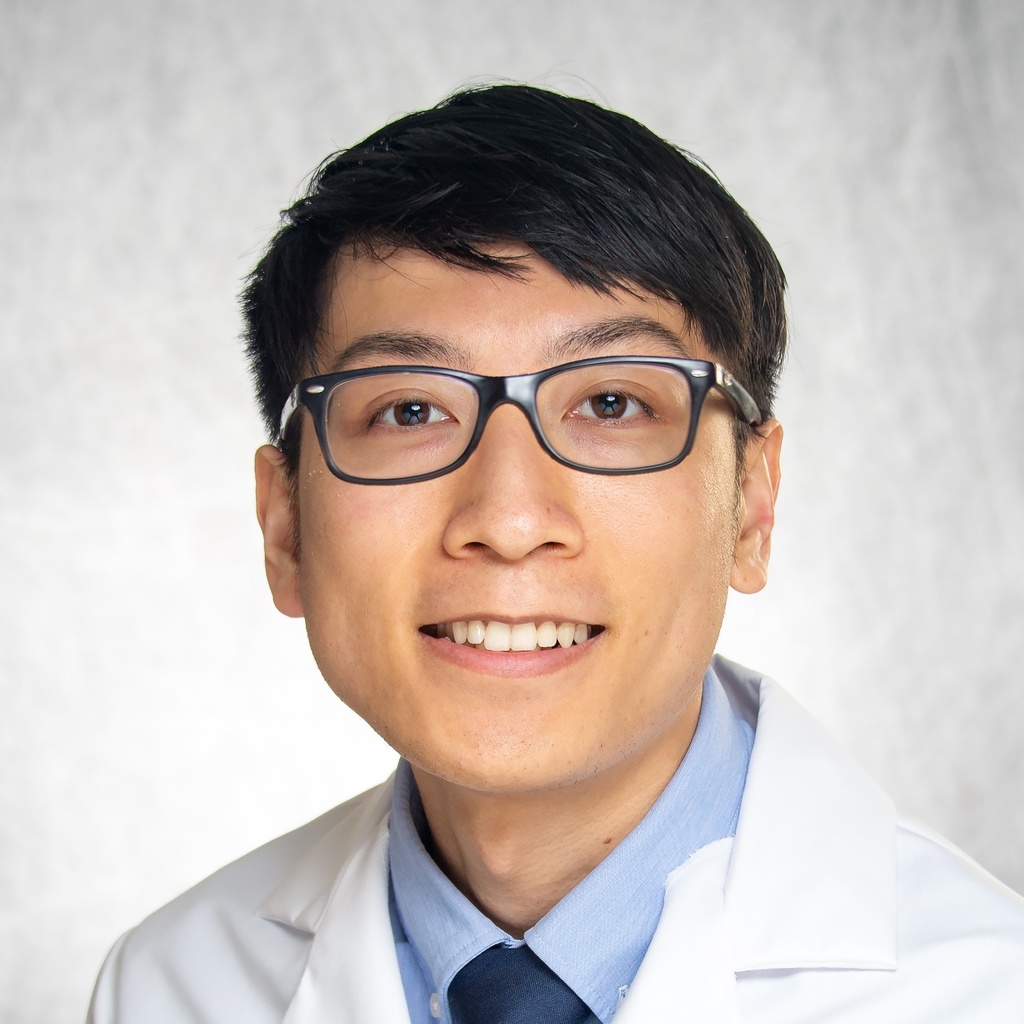 Dr. Cheung, a man wearing glasses and a white coat.