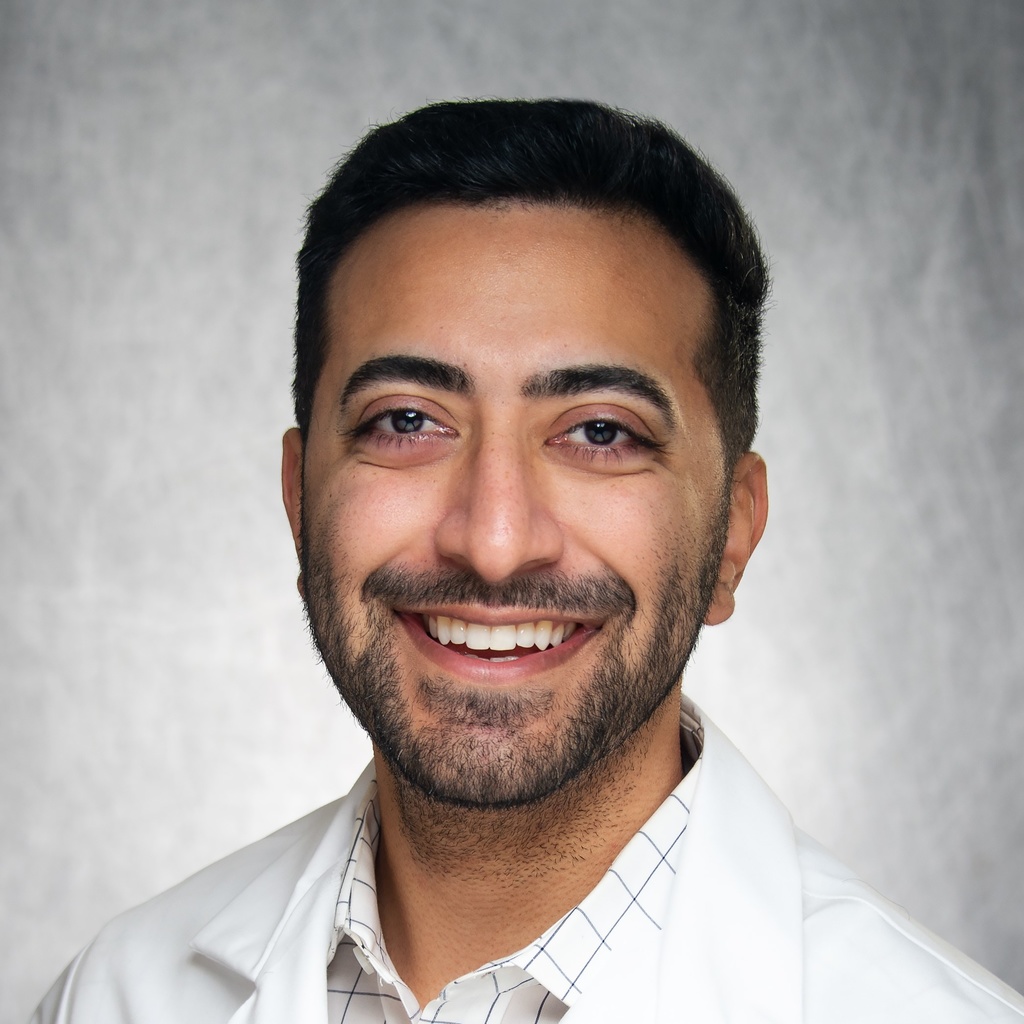 Dr. Abid, a smiling man in a white coat.