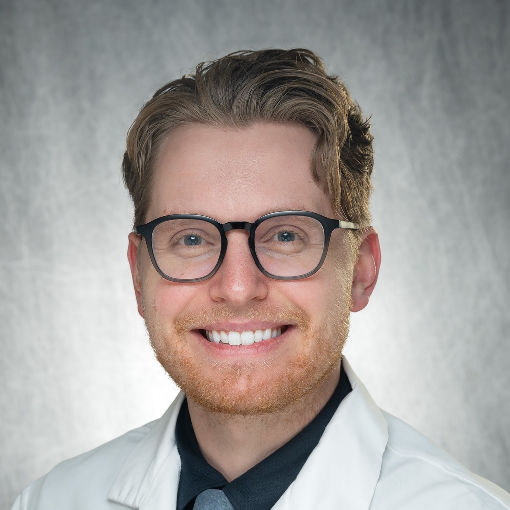 Dr. Shaver, a smiling man with glasses wearing a white coat.