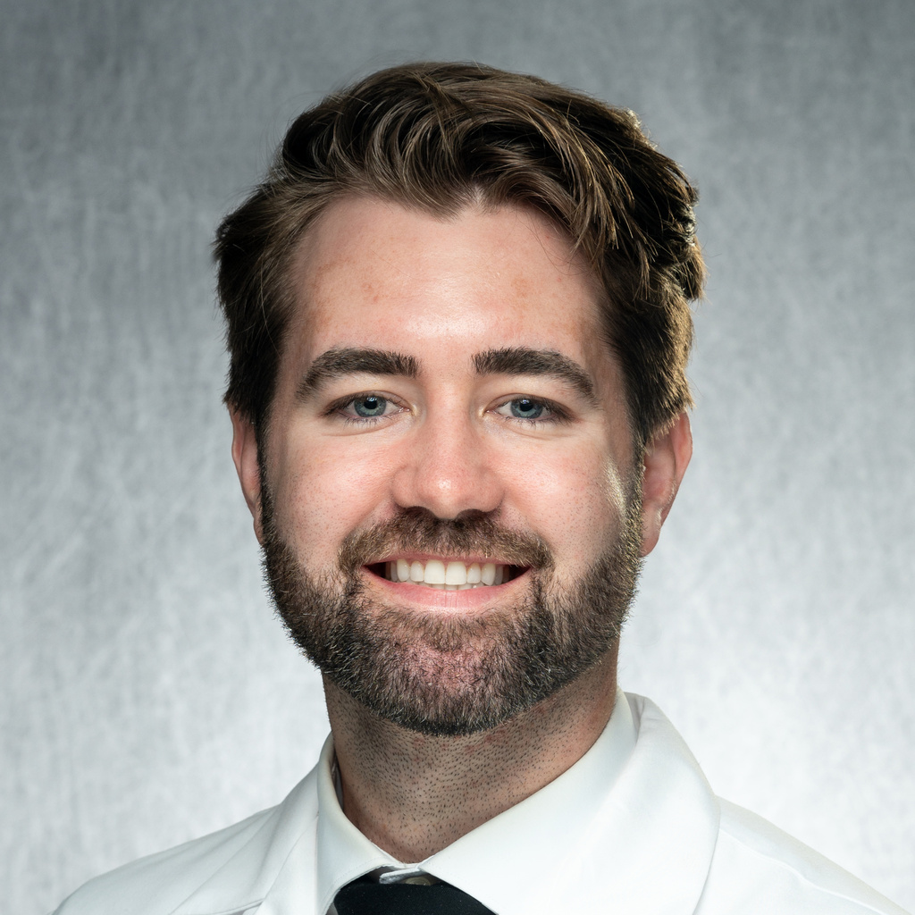 Dr. Markham, a man wearing a white shirt, black tie and white coat