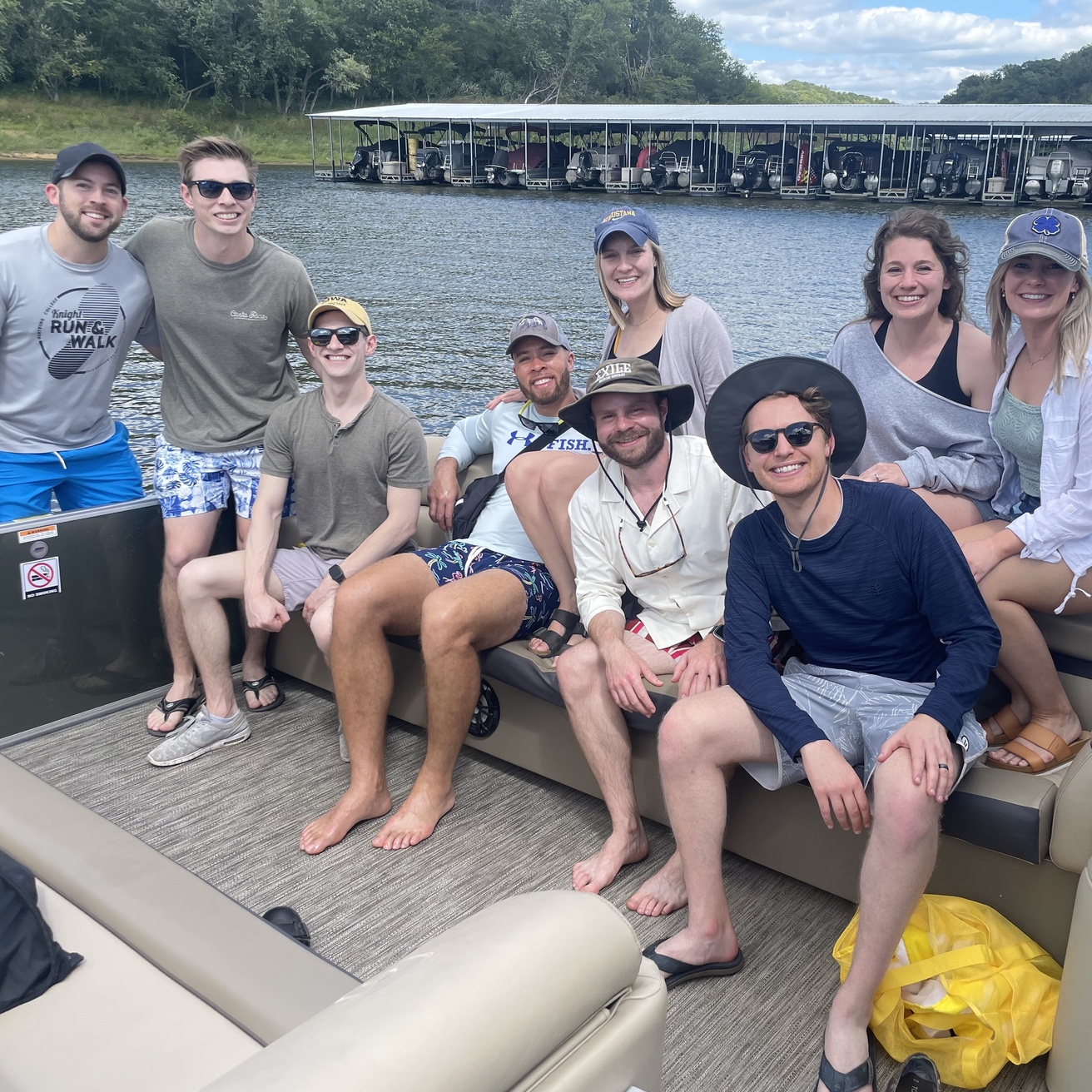 A group of people sit and smile on a boat.