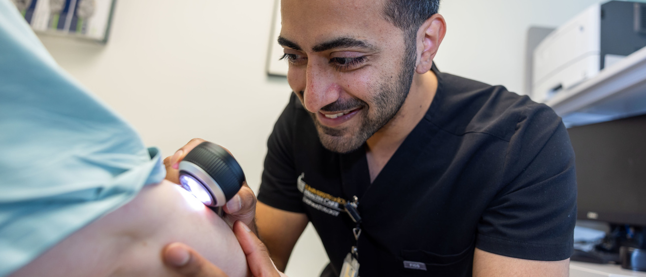 Dr. Abid examines a patient's arm.