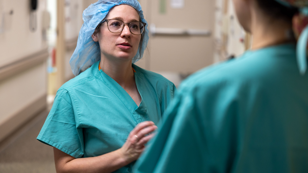 Two Doctors wearing scrubs having a discussion