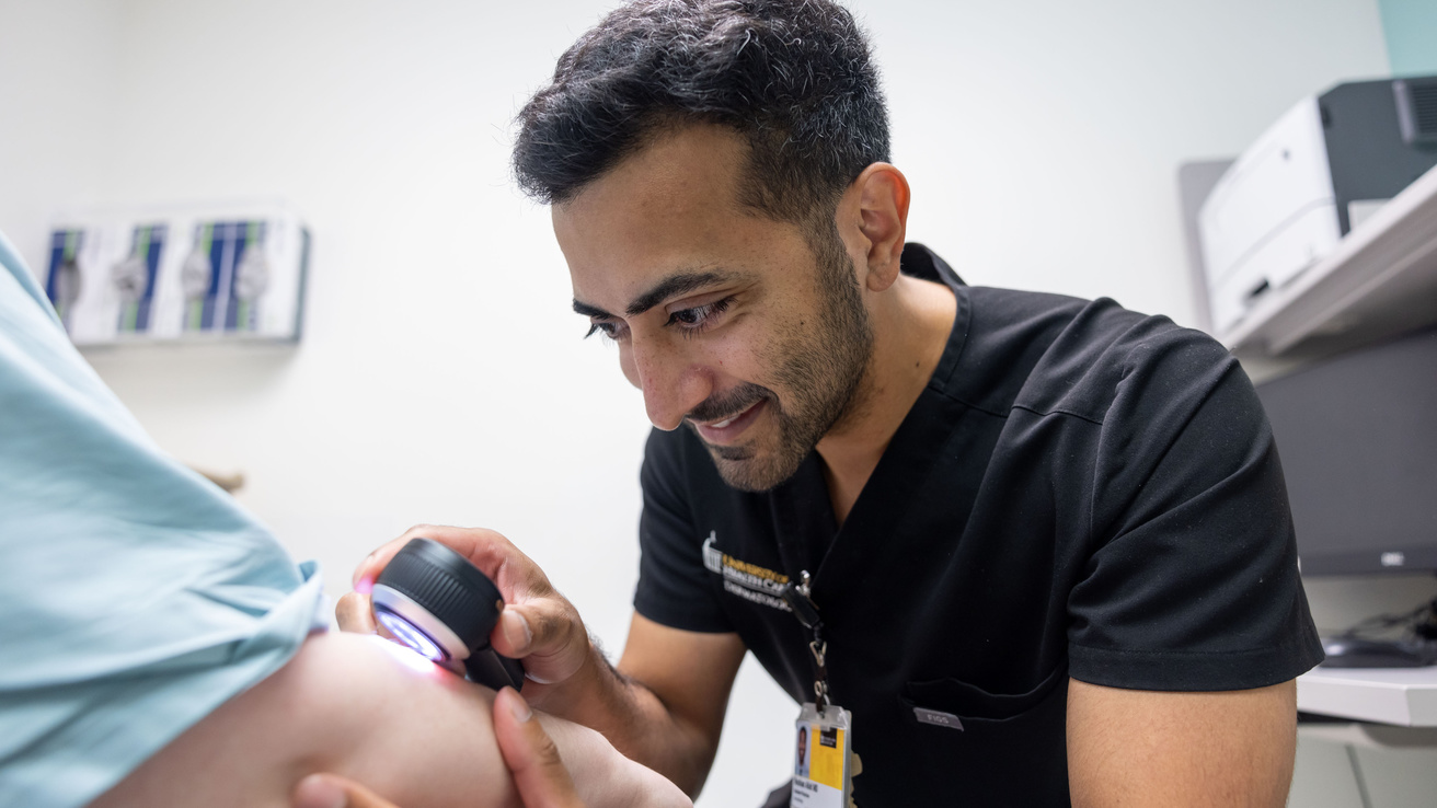 Doctor performing a skin exam on patient's arm